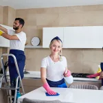 Cleaning service team at work in kitchen in private home