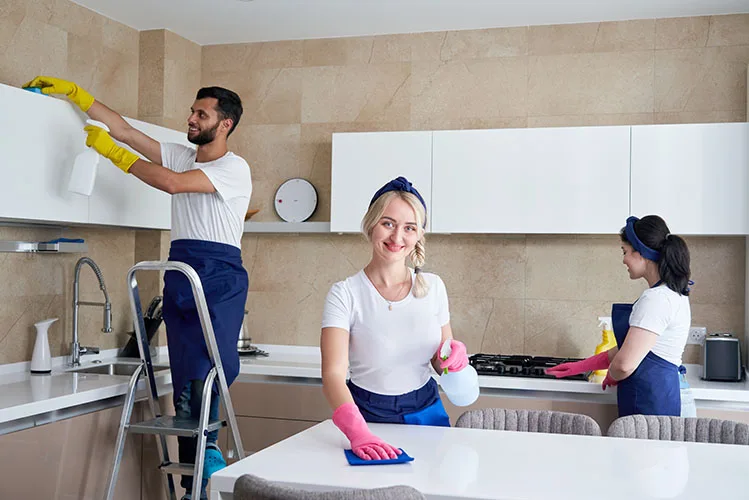 Cleaning service team at work in kitchen in private home