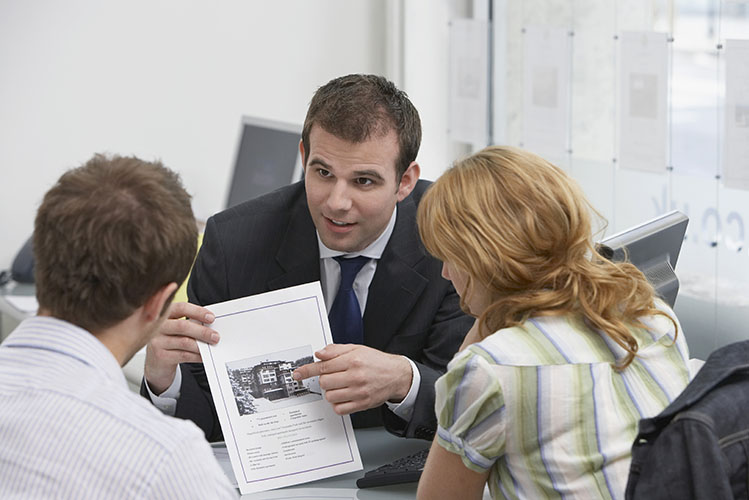 couple with real estate agent in office