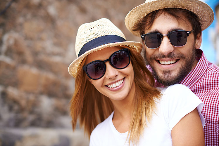 happy couple wearing hats and sunglasses