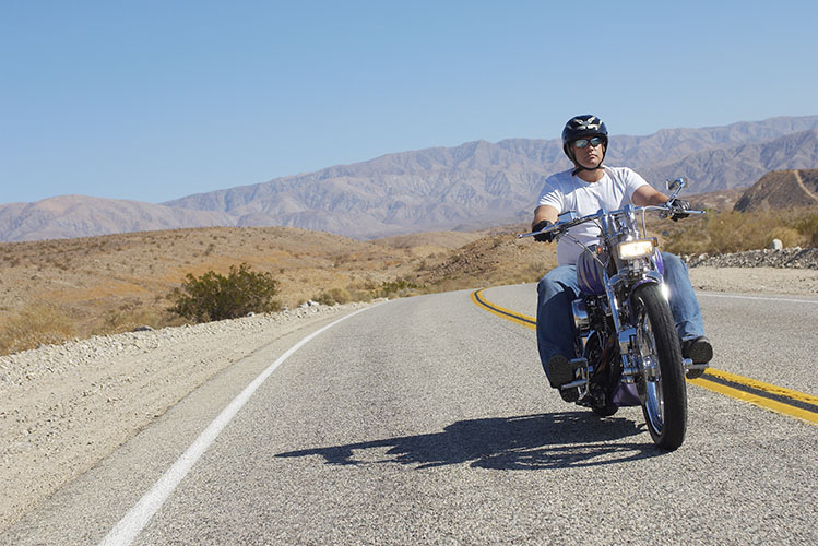 Man riding motorcycle on desert road