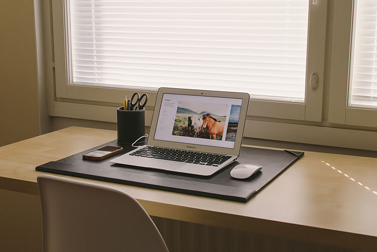 white laptop on wooden desk