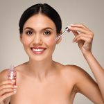 woman apply serum to skin face