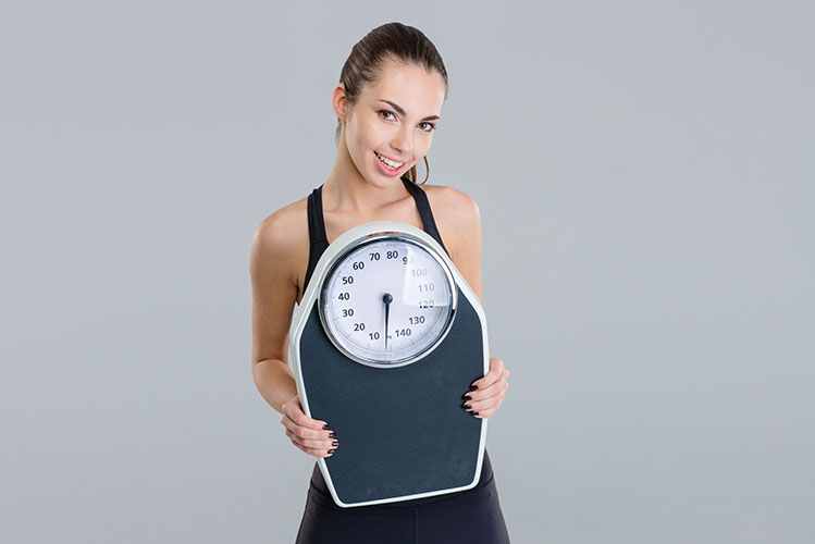 young woman holding weight scale